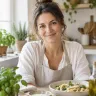 Ritratto di una donna sorridente con i capelli castani raccolti, in una cucina luminosa